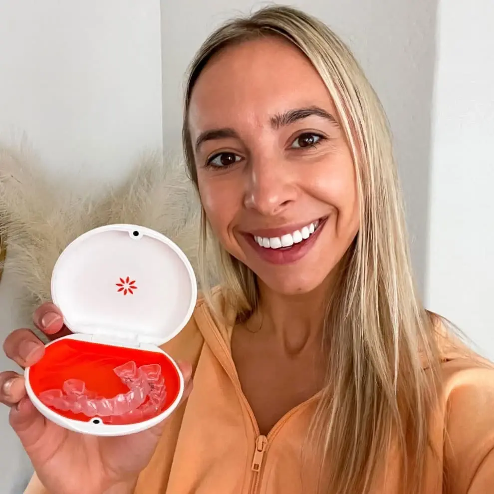 Woman holding a clear Vivera retainer
