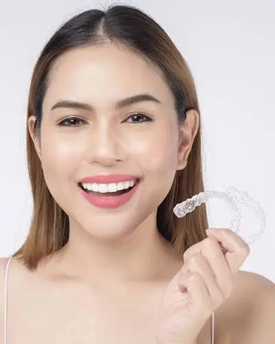 Illustrative portrait of a woman holding a clear Invisalign aligner